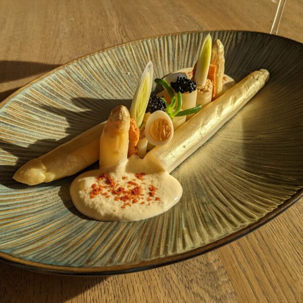 Top view of the dish "Golden Asparagus" with sea banana, caviar & mousseline